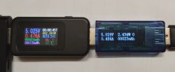 Dwa mierniki USB pokazujące różne dane o napięciu, prądzie i mocy.
