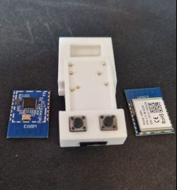 3D-printed flashing jig with two ESP-WROOM-32 modules beside it