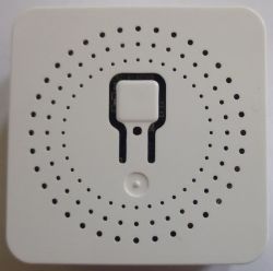 White Switch with Central Button Front view of a white switch with ventilation holes and a central button.