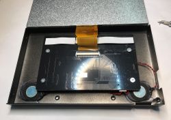 Inside of LCD monitor case showing main PCB and connected ribbon cable