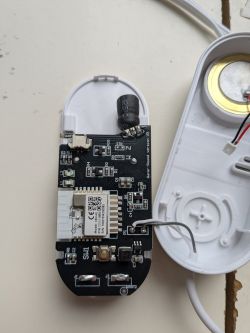 Opened electronic device with visible PCB, WiFi module, and piezo speaker.
