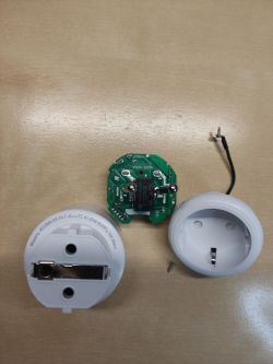 Disassembled Smart Plug with PCB Disassembled smart plug with visible PCB and casing.
