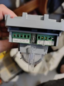 Zbliżenie na elektryczne złącza terminala z oznaczeniami POWER, ALARM, SP, TAMPER