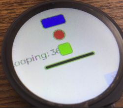 Okrągły wyświetlacz ESP32-S3-Touch-LCD-1.28 z grafiką testową: kolorowe figury i napis Looping: 36.