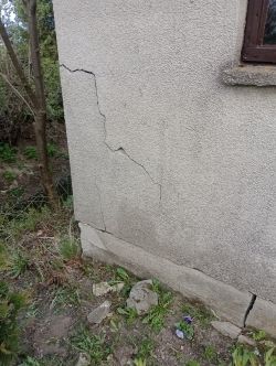 Pęknięcia na narożu ściany garażu zewnętrznego.