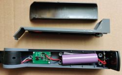 Wnętrze obudowy lampki z wyjętym akumulatorem.