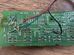 Close-up of a circuit board with removed components, added new switches and resistors, and wires.