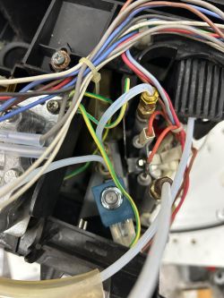 Wnętrze ekspresu do kawy z widocznymi kablami, przewodami i elektrozaworem.