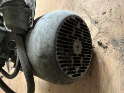 Widok zbliżony na metalową obudowę silnika elektrycznego z wentylacyjnymi otworami.