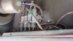 Zbliżenie na metalowe elementy i przewody elektryczne w komorze pojazdu, z trzema cylindrycznymi modułami
