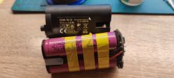 Two Comparative Batteries Two batteries, one labeled DCBK-70-12, the other partially disassembled with yellow tape.