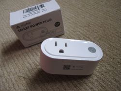 MOES Matter Smart Plug with Box MOES Matter smart plug lying on a carpet next to its box.