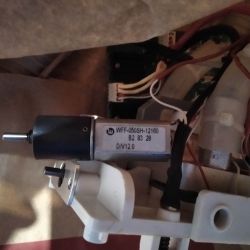 Elektrosilnik z oznaczeniem WFF-050SH-12160 zamocowany na plastikowym uchwycie.