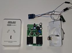 Disassembled Arlec Grid Connect smart plug with PCB, casing parts, and connected wires on a white surface