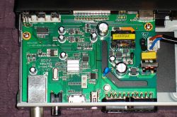 Zbliżenie na płytkę drukowaną tunera z różnymi elementami elektronicznymi.