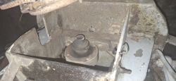 Zardzewiała konstrukcja mechaniczna z widoczną częścią wału