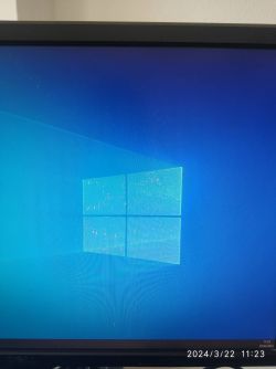 Ekran z niebieskim tłem i logiem Windows, widoczne czerwone kropki i paski zakłóceń.