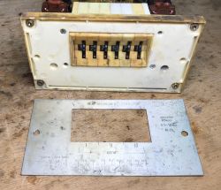 Disassembled timer relay panel with number sliders and a metal plate with Cyrillic labels on a workbench