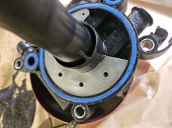 Część mechaniczna z czarną rurką prowadzącą do okrągłej podstawy z niebieskimi uszczelkami oraz widoczną blaszką.