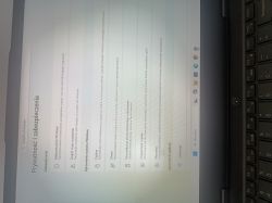 Ekran laptopa z ustawieniami Windows „Prywatność i zabezpieczenia”, widoczna klawiatura