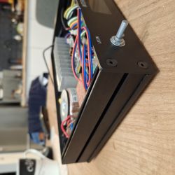 Corner of a black electronic device case with encoder and visible wiring.