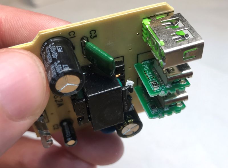 Close-up of power supply PCB with capacitors, USB ports, and electronic components