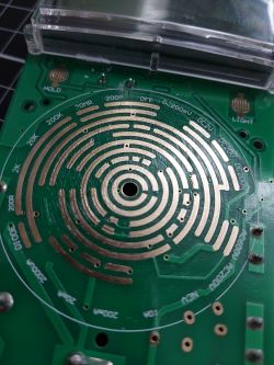 Image of a multimeter interior showing a dusty printed circuit board.