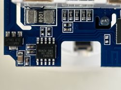 Close-up image of a circuit board with visible electronic components, including integrated circuits and capacitors.