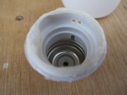 Interior of a plastic cap with a visible spring inside.