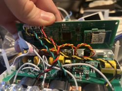Main circuit board of an electronic device with connected cables.