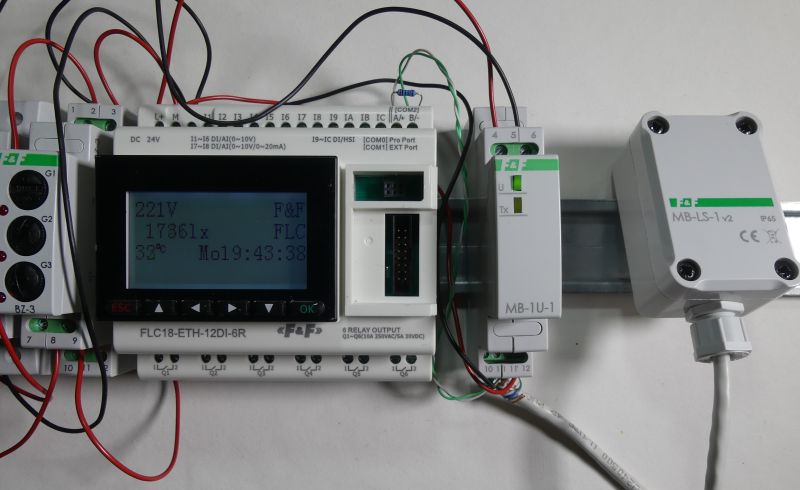 Panel sterowania automatyki z wyświetlaczem LCD, sterownikami i czujnikiem zamontowanymi na szynie DIN.