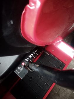 Metalowy drążek na czerwonej platformie z oznaczeniami w języku angielskim.