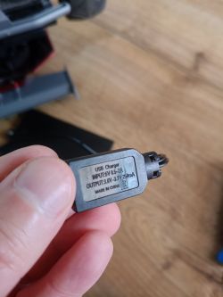 Zbliżenie na wtyczkę ładowarki USB z danymi technicznymi na etykiecie