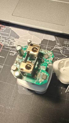 Disassembled Wi-Fi Smart Plug Disassembled Wi-Fi smart plug lying on a world map.