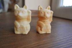 3D Printed Cat Figurines Two 3D printed cat figurines on a wooden surface.