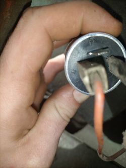 Widok na metalową beczkę ze złączami elektrycznymi, trzymaną w ręce