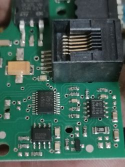 Zbliżenie na płytkę elektroniczną z gniazdem i elementami elektronicznymi.
