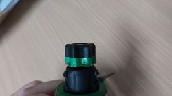 Zbliżenie na uszkodzony element noża Thermomix TM6 z plastikowymi częściami w czerni i zieleni.