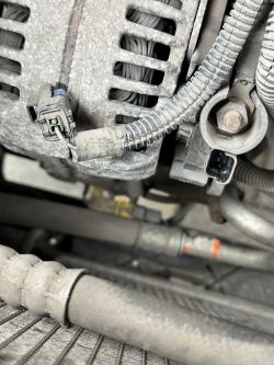 Widok alternatora z jednym przewodem podłączonym do kostki.