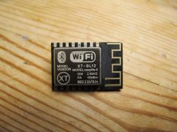 Wi-Fi XT-BL12 Module Wi-Fi XT-BL12 module lying on a wooden surface.