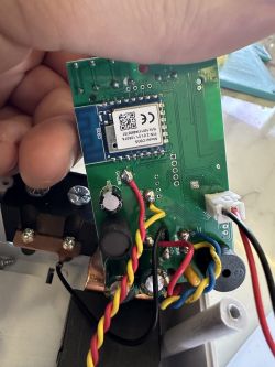 Circuit board with mounted electronic module, held by a person.