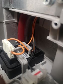 Wnętrze suszarki z przewodami elektrycznymi i czerwoną rurką.
