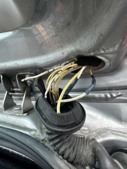 Przewody elektryczne z widocznymi uszkodzeniami izolacji w drzwiach samochodu