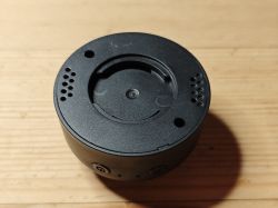 Black electronic device base or mounting bracket Black plastic device base or mount top view on wooden surface