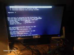 Monitor wyświetlający ekran instalatora systemu Windows 98 w trybie tekstowym, z widocznym wyborem opcji uruchomienia i informacjami o sterownikach.