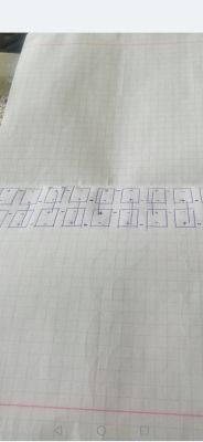Rysunek na papierze w kratkę pokazujący połączenia kilku baterii z oznaczeniami plus i minus.