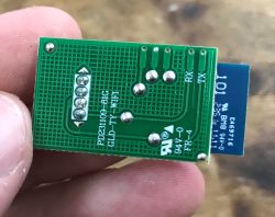 WiFi module WBR3 with labeled pins RX, TX, GND, and 3.3V, held between fingers.