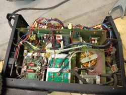 Wnętrze urządzenia elektronicznego z widocznymi kablami i komponentami.