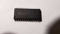 Close-up of a black TDA7313D IC marked “KOREA” on a white surface