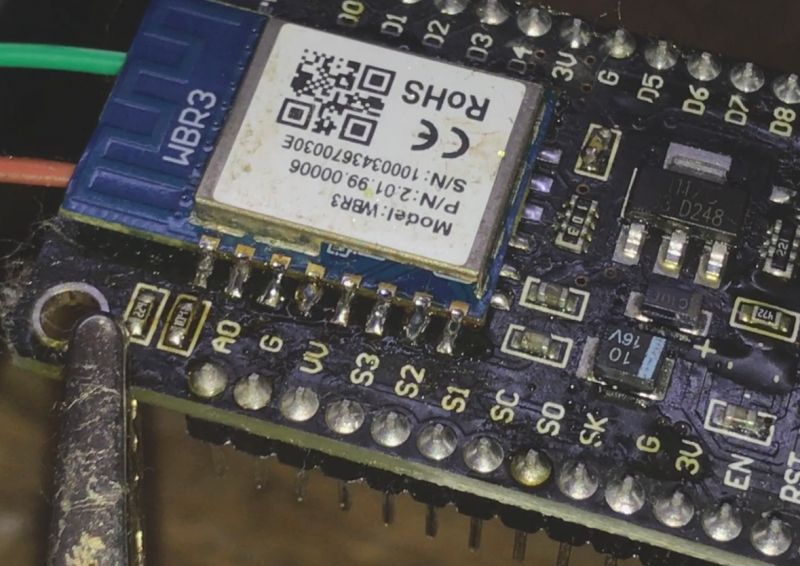 Close-up of an electronic module with a soldered WBR3 chip and connected wires.
